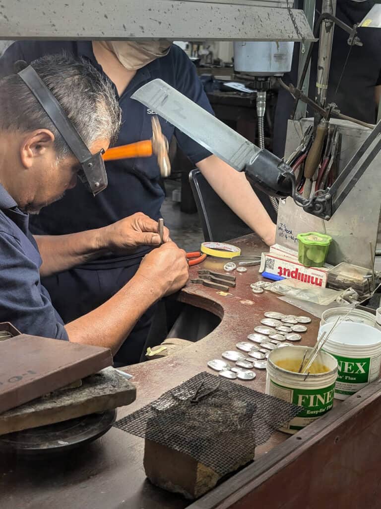 Человек работает с оловом в Royal Selangor Visitor Centre